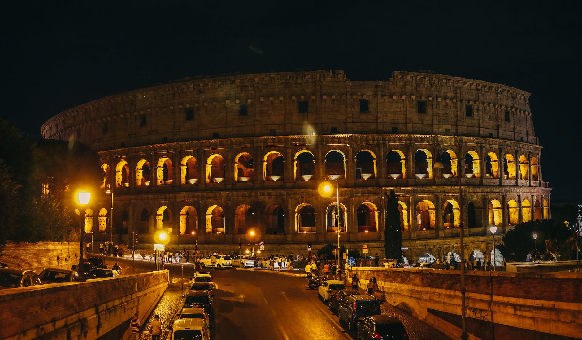 cars parked in front of rome colosseum